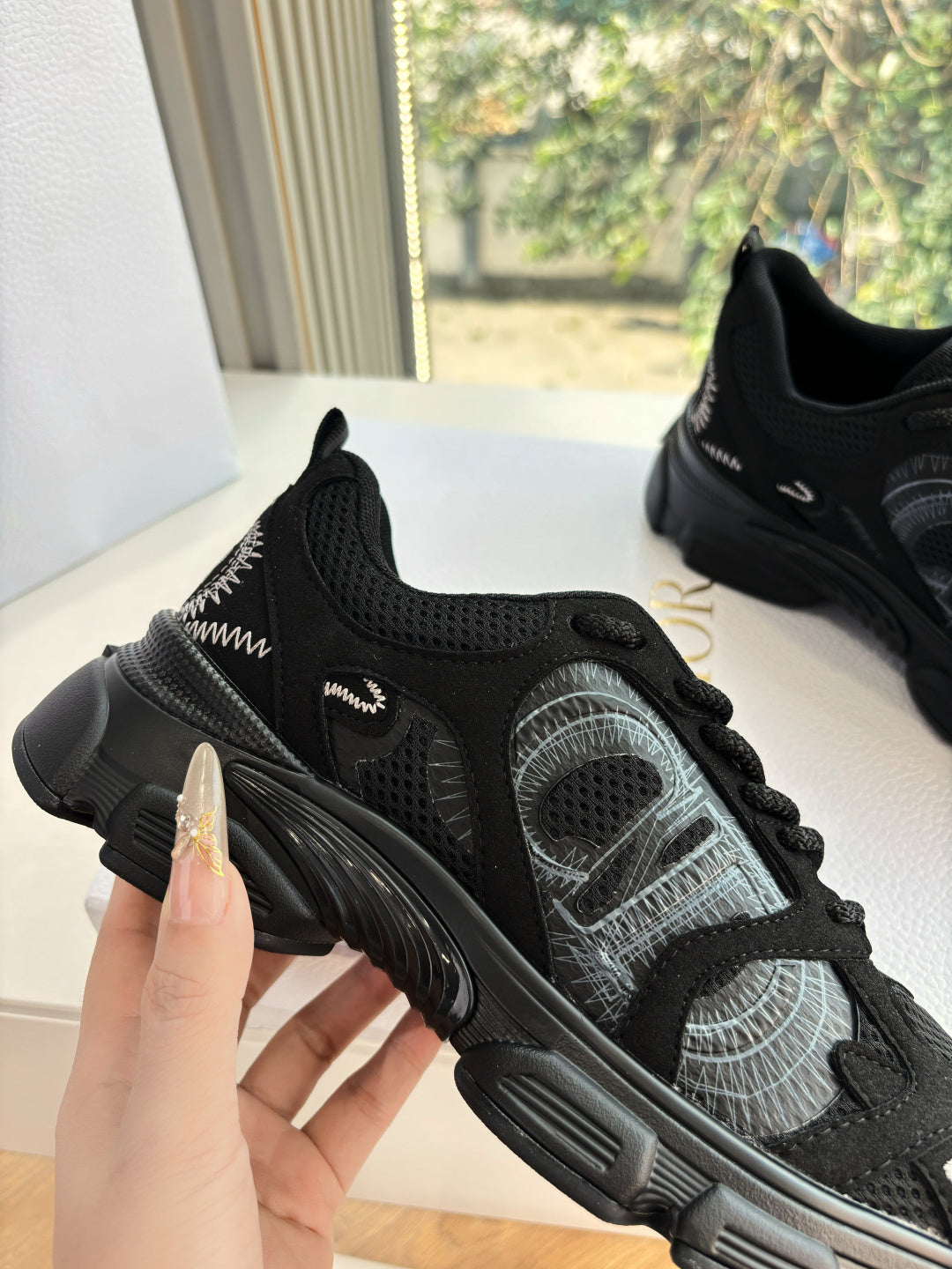 Black lace-up sneakers close-up with breathable mesh and thick sole