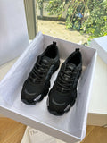 Black lace-up sneakers in a box with black mesh and cushioned sole