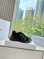 Black lace-up sneaker sitting on a shoebox ledge
