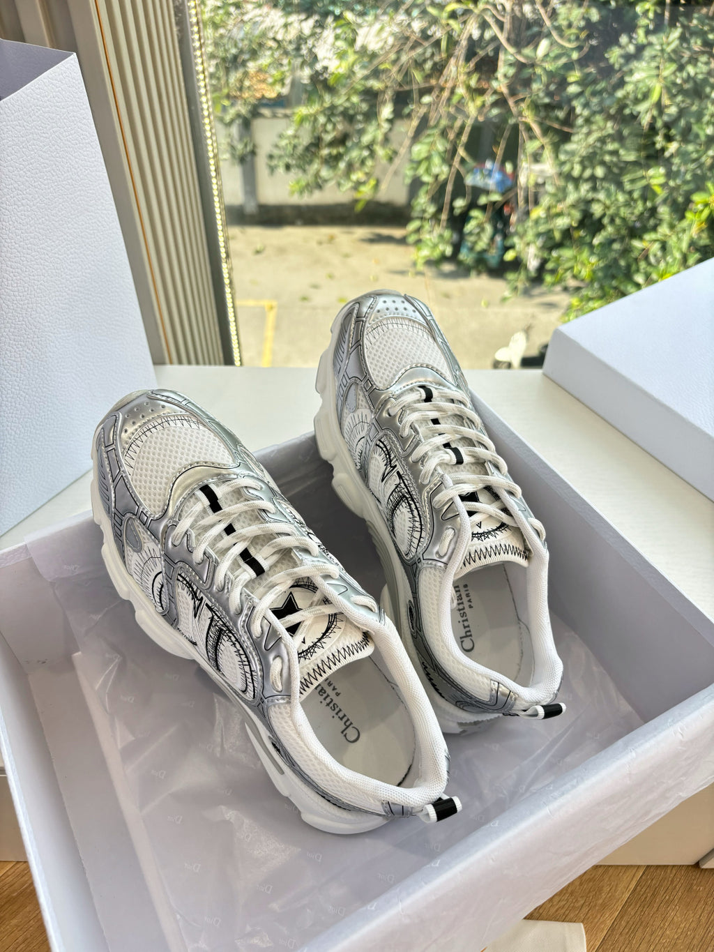 Ladies' gray lace-up sneakers with white laces, shown in a shoe box
