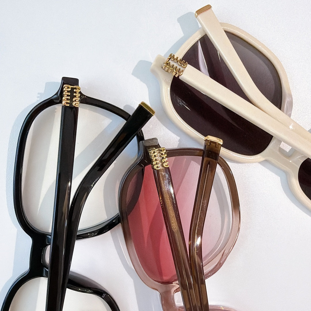 MiuMiu white sunglasses with brown lenses; side temples and gold-tone hinges visible.