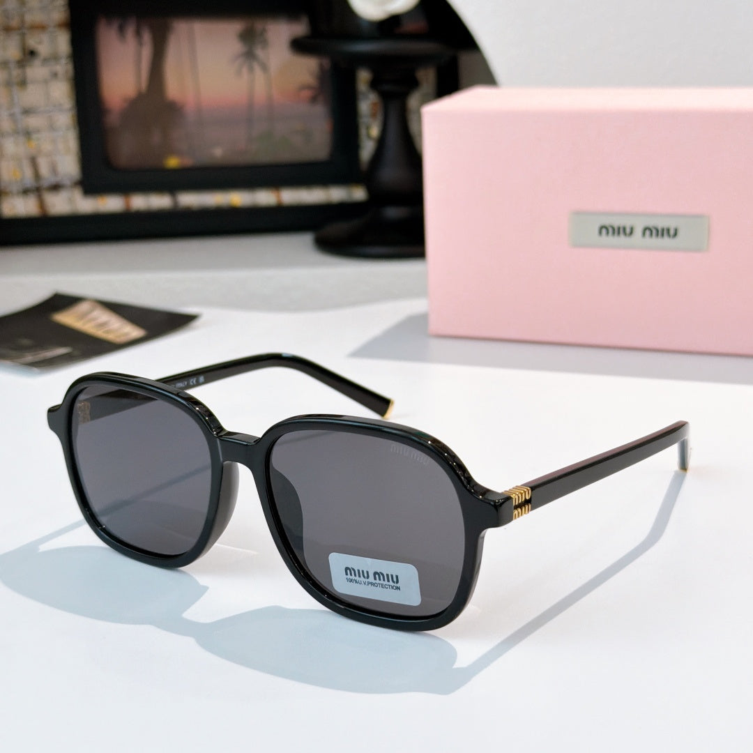 MiuMiu black sunglasses with dark lenses and gold-tone hinges; logo on temple.