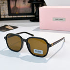 MiuMiu black sunglasses with amber lenses and gold-tone hinges; logo on temple.