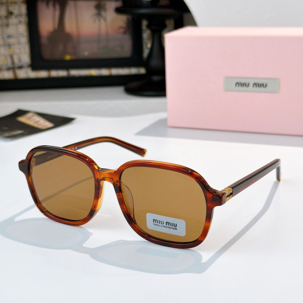MiuMiu orange-brown tortoise sunglasses with amber lenses and gold-tone hinges; logo on lens.