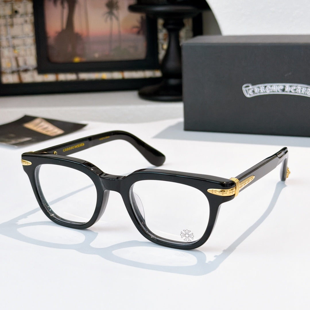 Black eyeglasses with clear lenses and gold-accented temple tips.