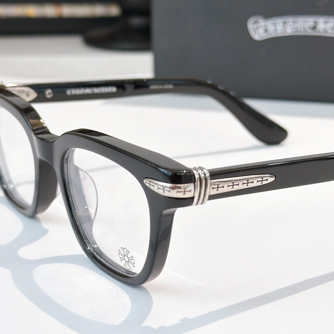 Black eyeglasses close-up with patterned temples and clear front lenses.