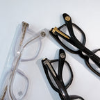 Black and transparent eyeglasses with clear lenses, shown side by side.