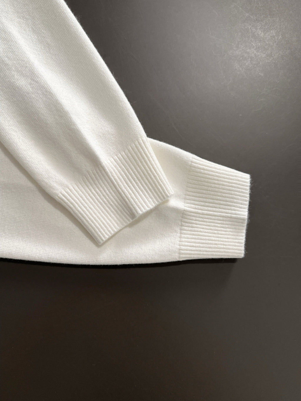 White Versace sweatshirt cuff close-up with ribbed collar and knit hem