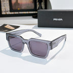 Prada sunglasses with clear gray frame and purple-tinted lenses, cat-eye