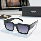 Prada sunglasses with dark frame and purple-tinted lenses, wide rectangular