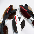 Stacked sunglasses with black frames and dark lenses, plus brown-lens pair
