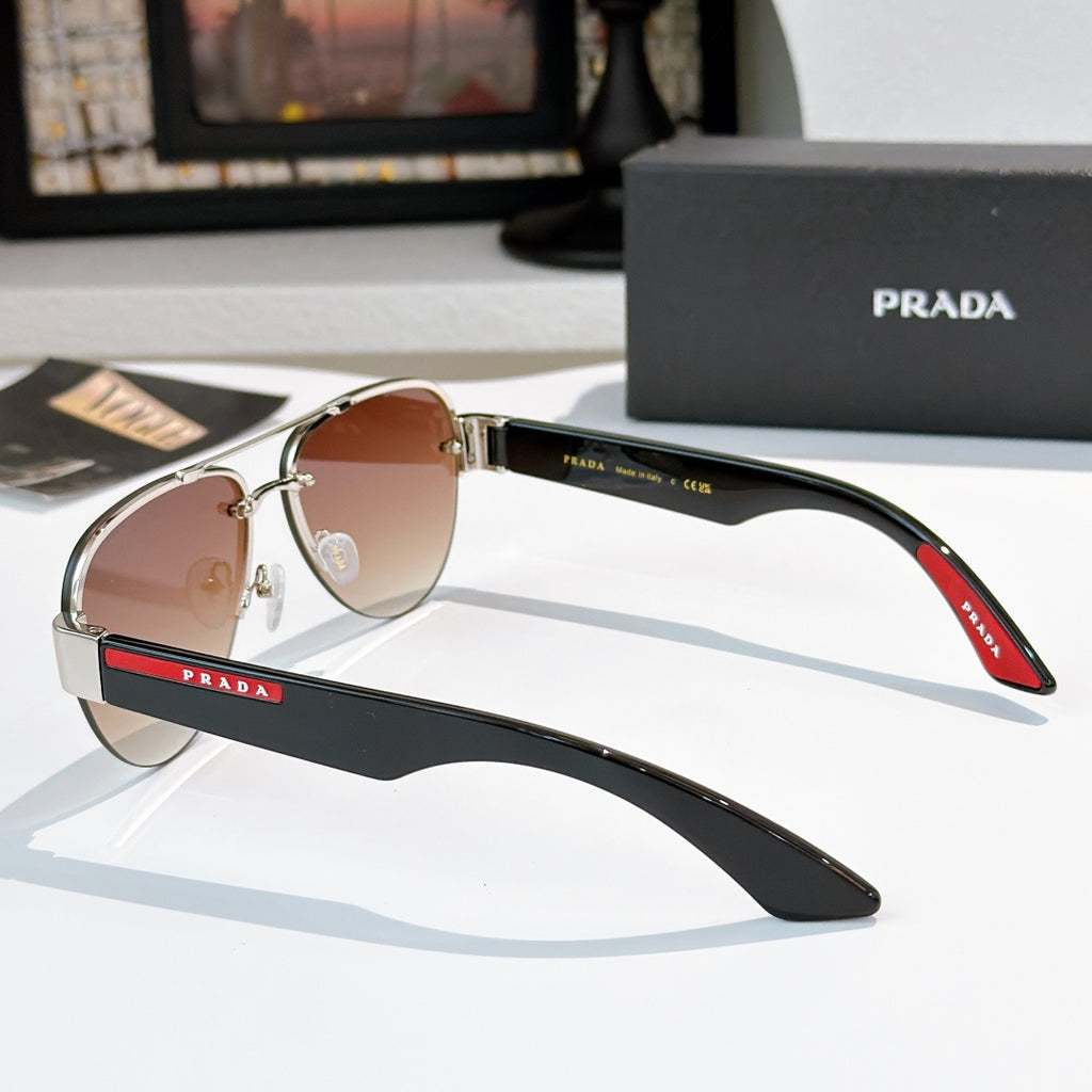 Aviator sunglasses with amber lenses and silver frame, black temple with red logo