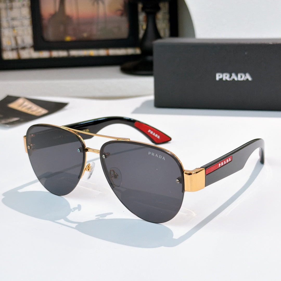 Aviator sunglasses with dark gray lenses, gold frame, and red logo temple detail