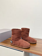 Brown suede ankle boots on display shelf, with Balenciaga logo tabs on sides