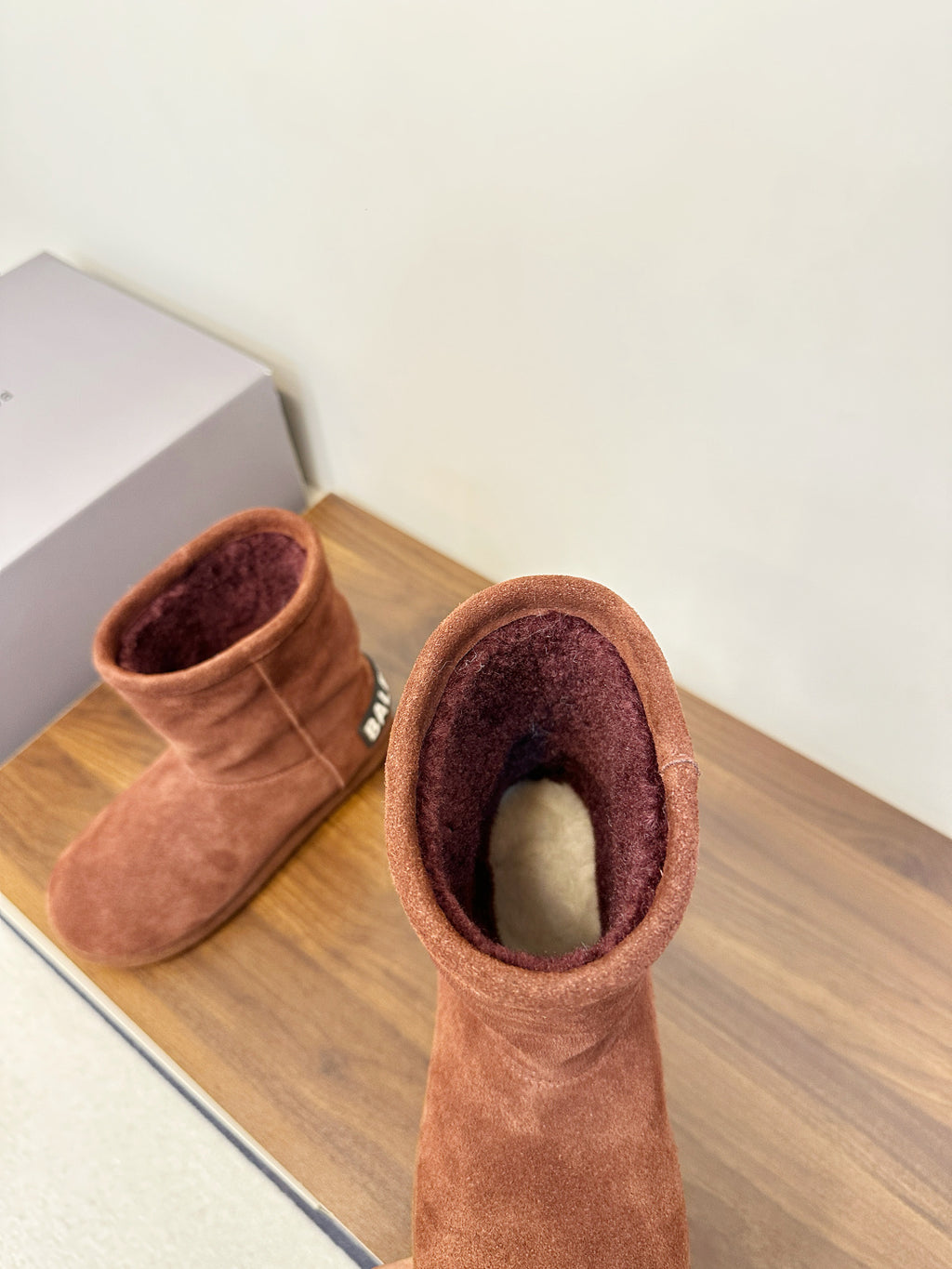 Brown suede ankle boots with interior lining visible, pair side view
