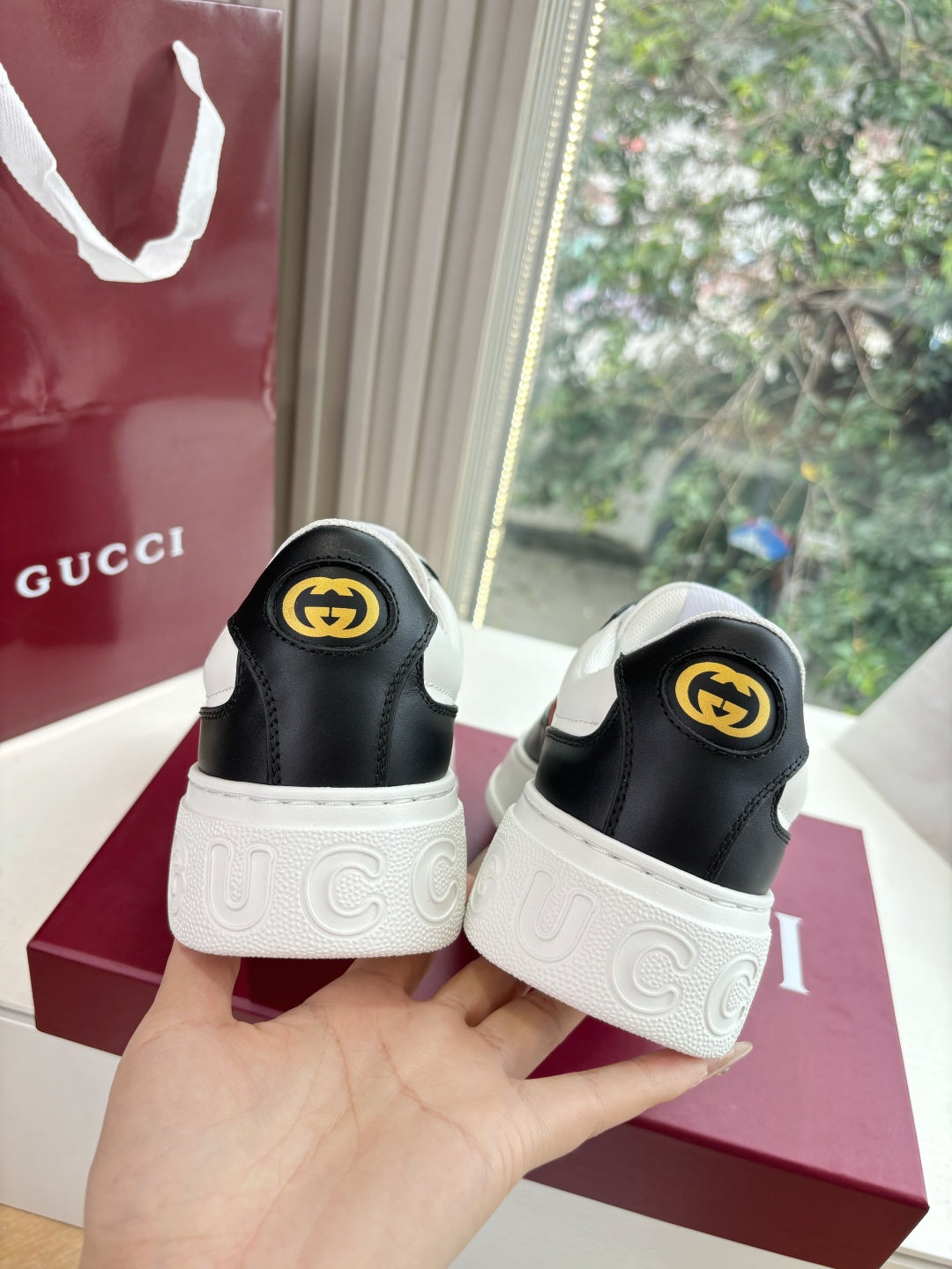 Gucci low-top sneakers, back view with black uppers and white logo outsole