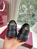 Gucci women's black leather sneakers, back view with circular GG logo accents