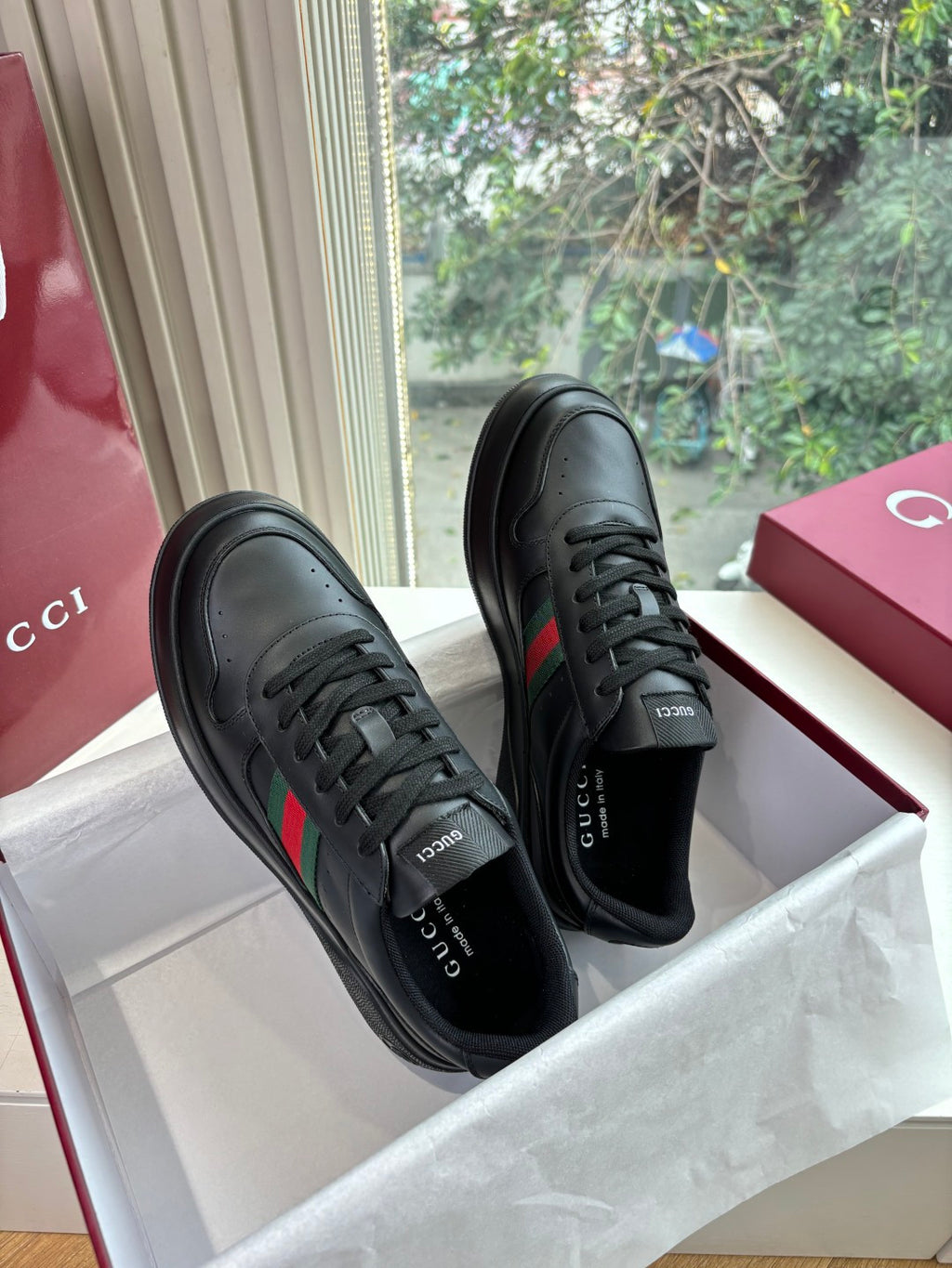 Gucci women's black leather sneakers pair, lace-up style with side stripe accents