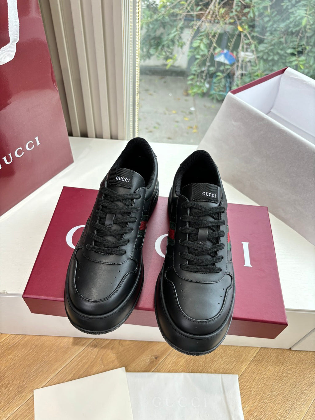 Gucci women's black leather sneakers, front view with lace-up closure and branding