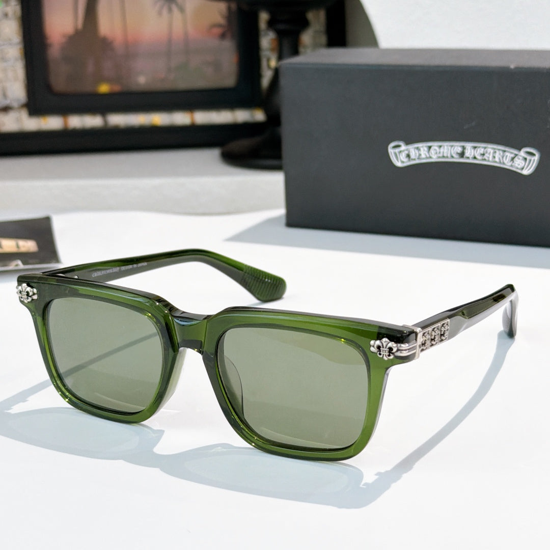 Sunglasses with green-tinted lenses, green frame, and silver ornate temple details.