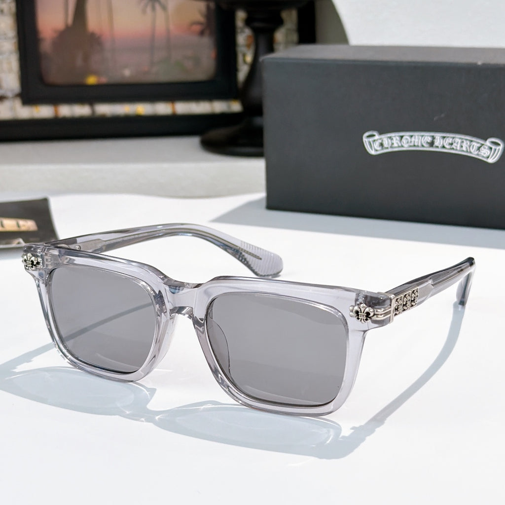 Sunglasses with gray lenses, clear frame, and silver ornate temple hardware.