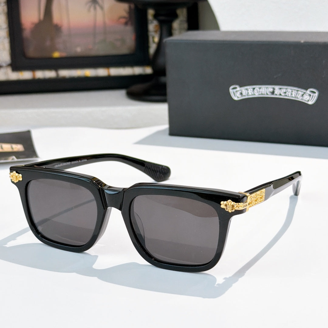 Sunglasses with dark lenses, black frame, and gold accent on the temples.