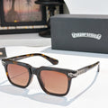 Sunglasses with brown-tinted lenses, black frame, and silver ornate temple details.