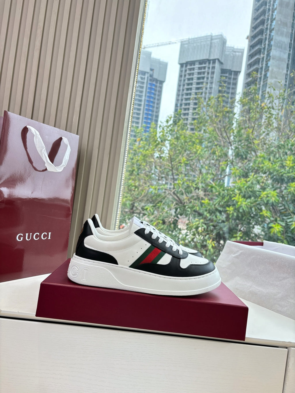 Gucci low-top sneakers, white-and-black with multicolor stripe across the side
