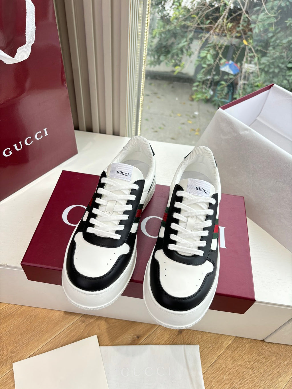Gucci low-top sneakers, white uppers with black side panels, lace-up front