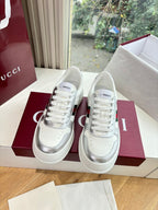 White Gucci leather sneakers pair, lace-up front with red and green side stripe