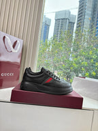 Gucci women's black leather sneakers, side profile with lace-up and stripe