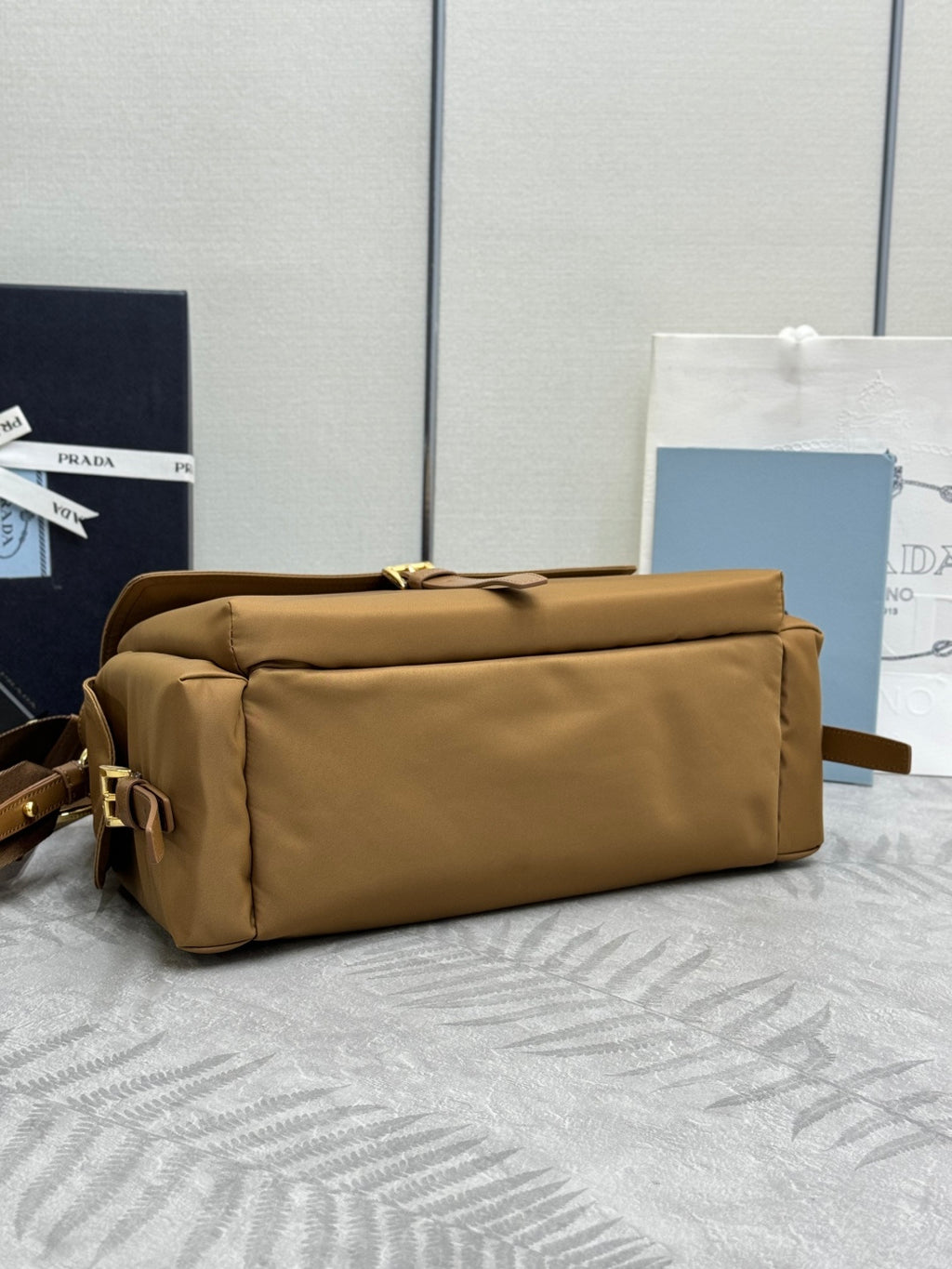 Tan nylon bag with gathered top, top handles, and minimalist front panel