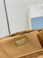 Close-up logo patch on tan flap reading "PRADA Made in Italy"