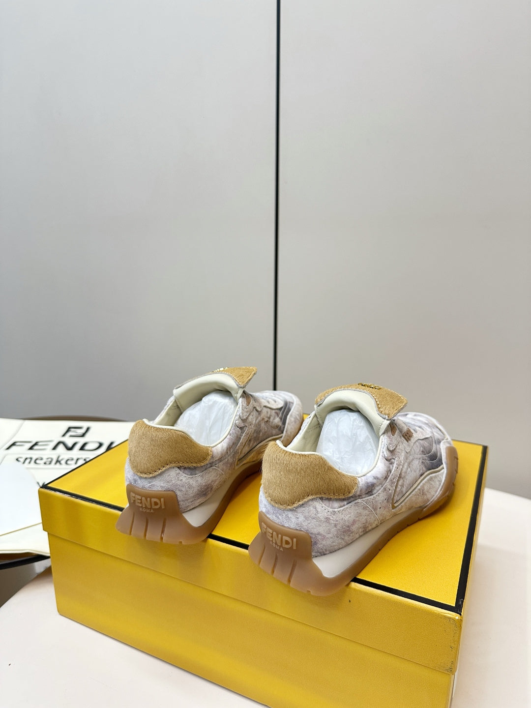 Fendi unisex sneakers, light gray uppers with tan back heel pull tabs.