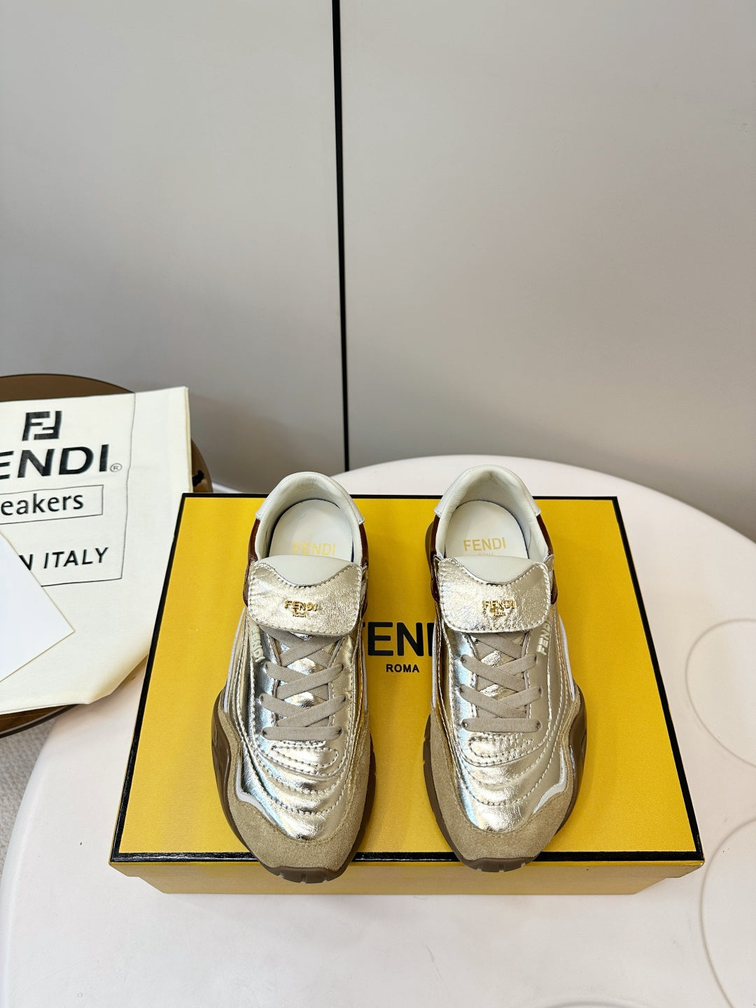 Fendi unisex low-top sneakers in metallic gold with brown side panels and white laces