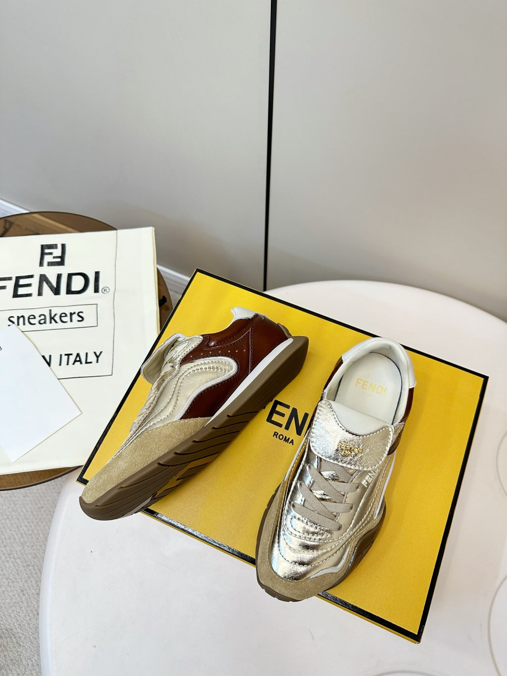Fendi unisex metallic gold sneakers with white laces, brown trim, and side logo
