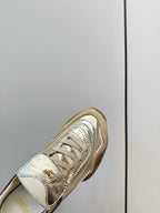 Fendi unisex sneaker close-up, metallic gold with brown collar lining and logo detail