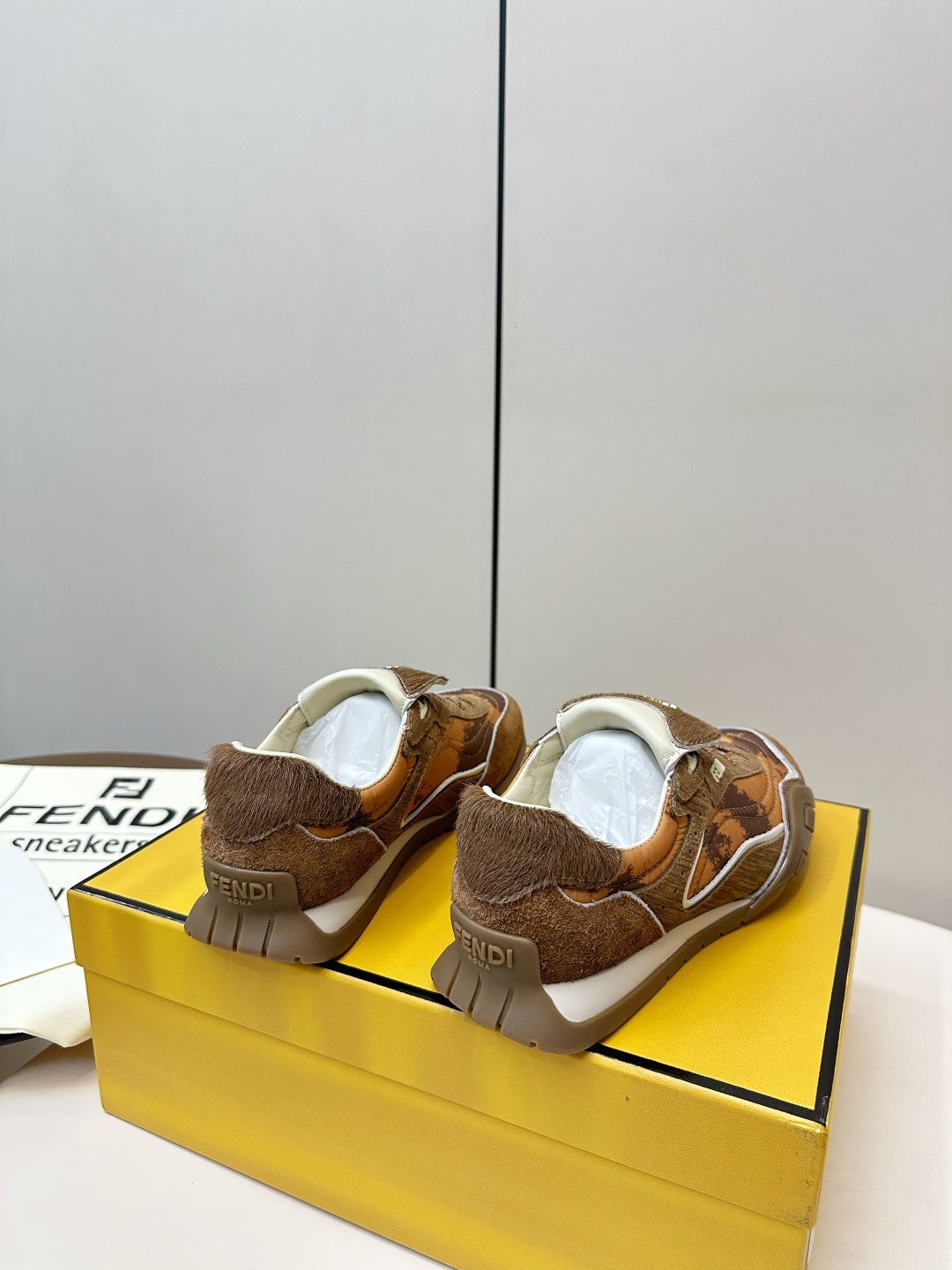 Fendi unisex sneakers, pair showing back view with white lining and brown uppers