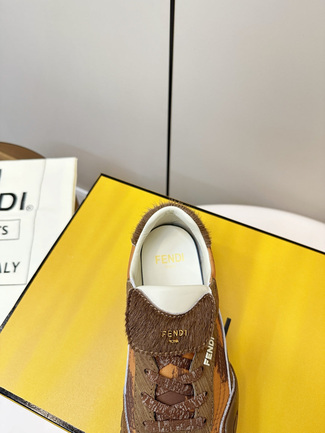 Fendi unisex sneakers front view, brown uppers with FENDI logo on tongue