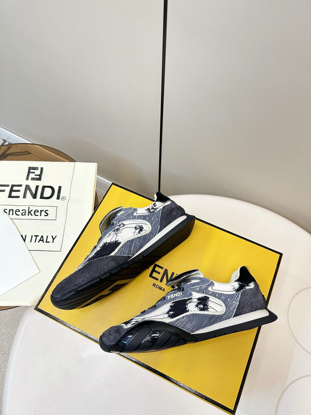 Fendi unisex sneakers on yellow box, navy and white pattern with black laces