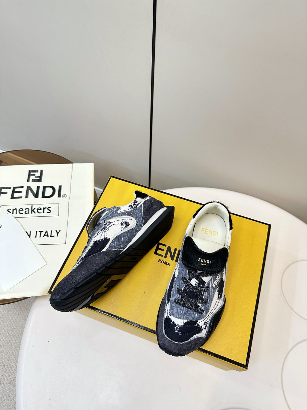 Fendi unisex sneakers on yellow box, navy and white patterned mesh with black sole