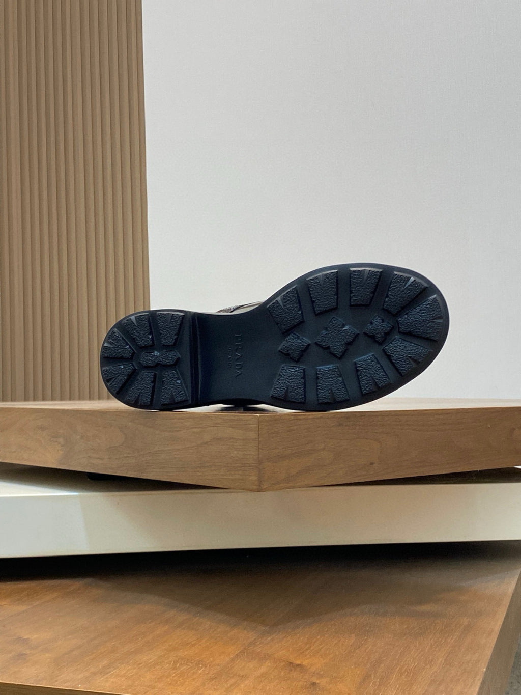Prada boot outsole view, textured dark rubber tread on a low platform sole