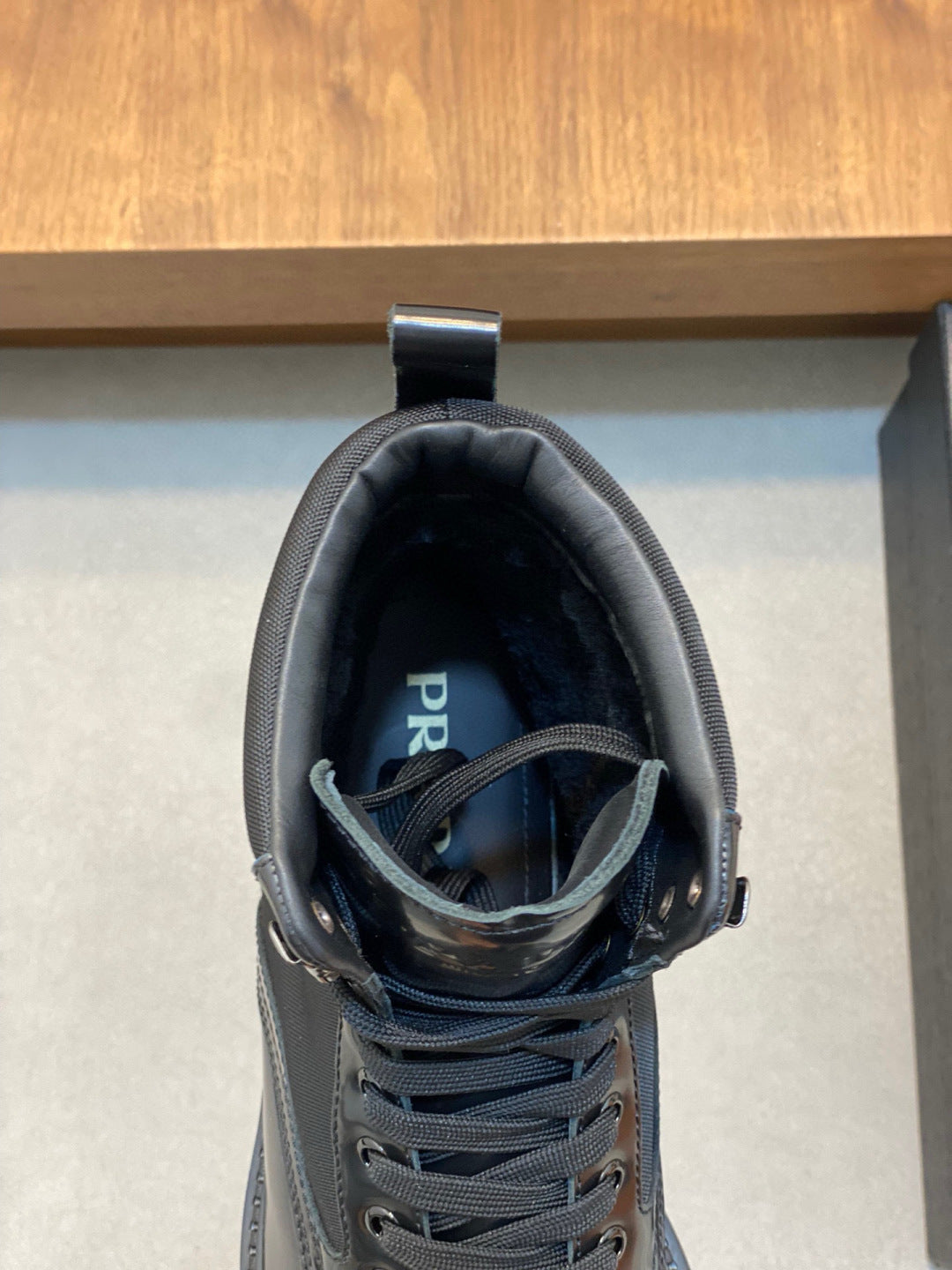 Prada boot interior view, lace-up dark blue upper with tongue label and padded collar