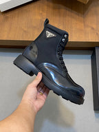 Hand-held Prada lace-up boot, glossy dark blue leather with logo patch and tread sole