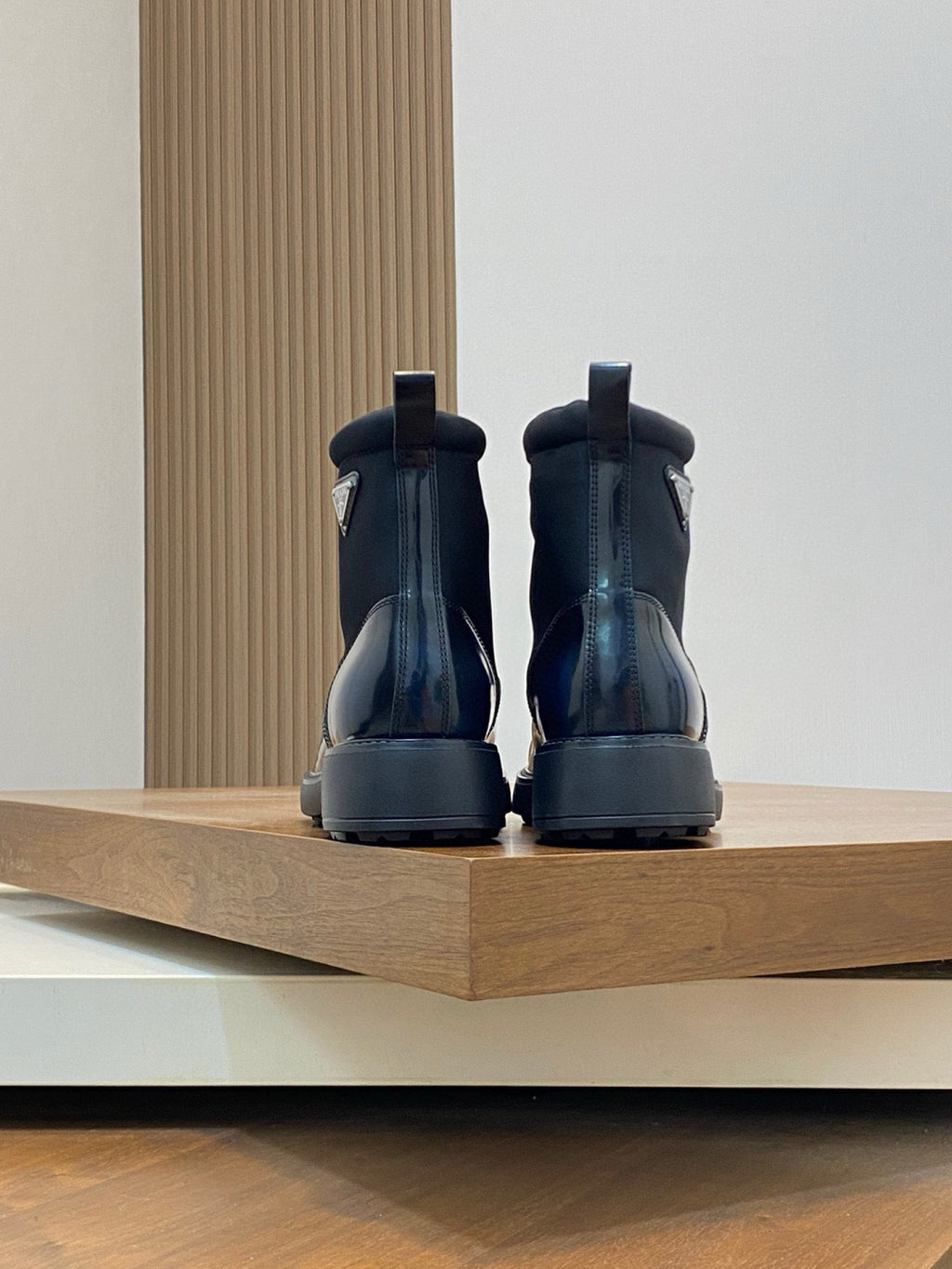 Prada lace-up ankle boots, rear view with heel tab, glossy dark blue leather and tread sole