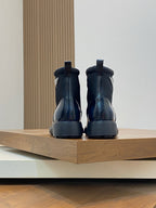 Prada lace-up ankle boots, rear view with heel tab, glossy dark blue leather and tread sole