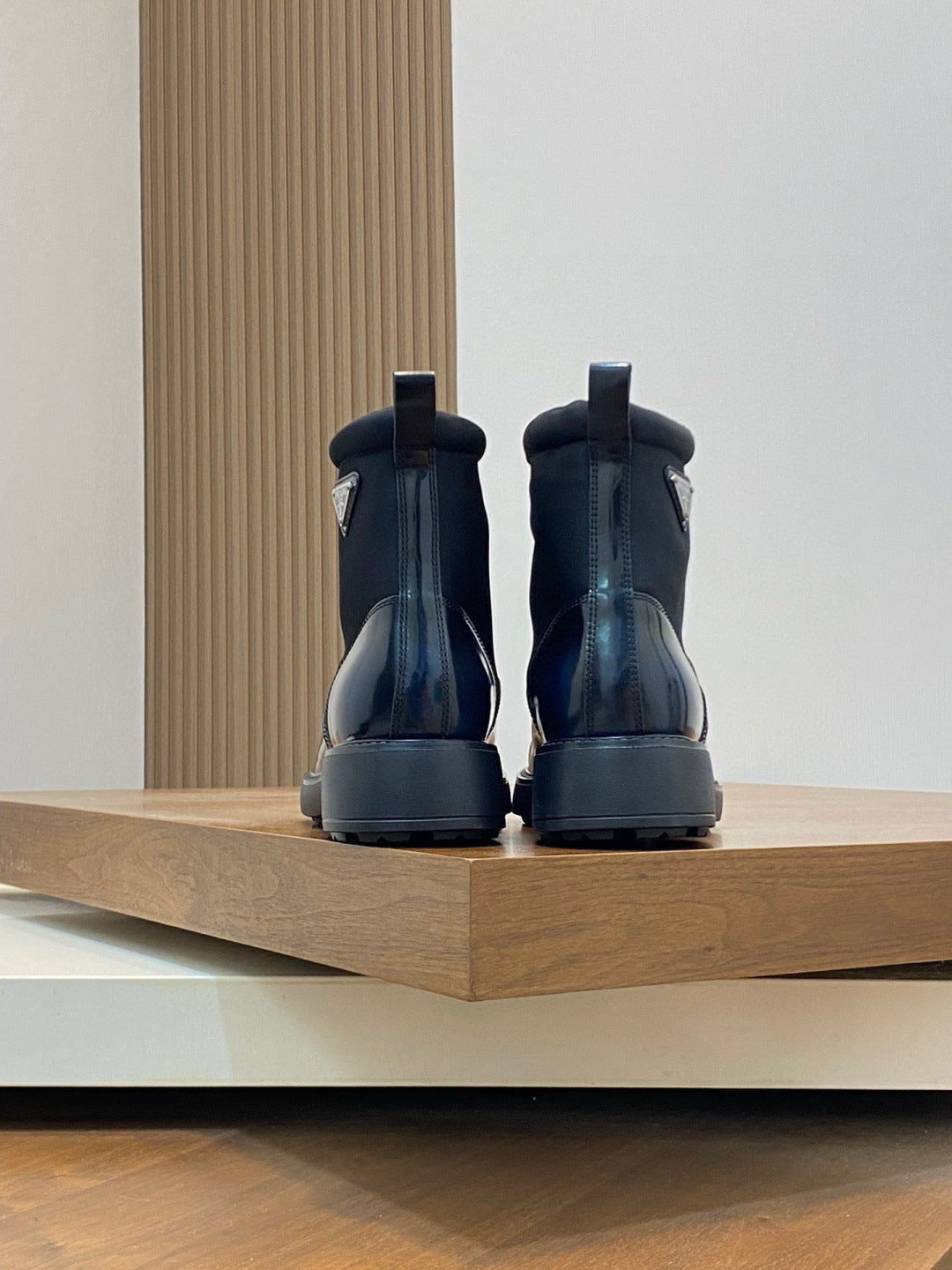 Prada lace-up ankle boots, rear view with heel tab, glossy dark blue leather and tread sole