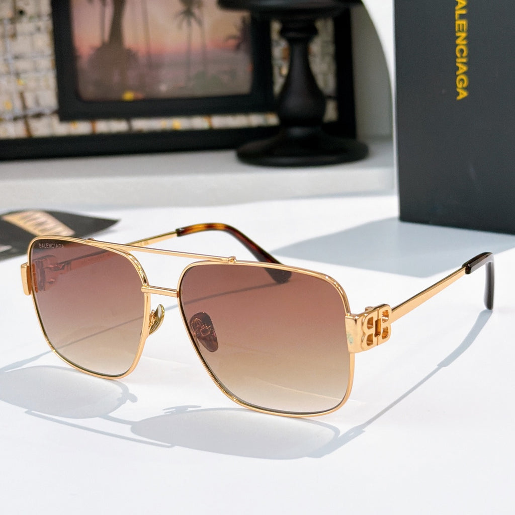 Gold-framed sunglasses with pink-tinted lenses and curved tinted bridge