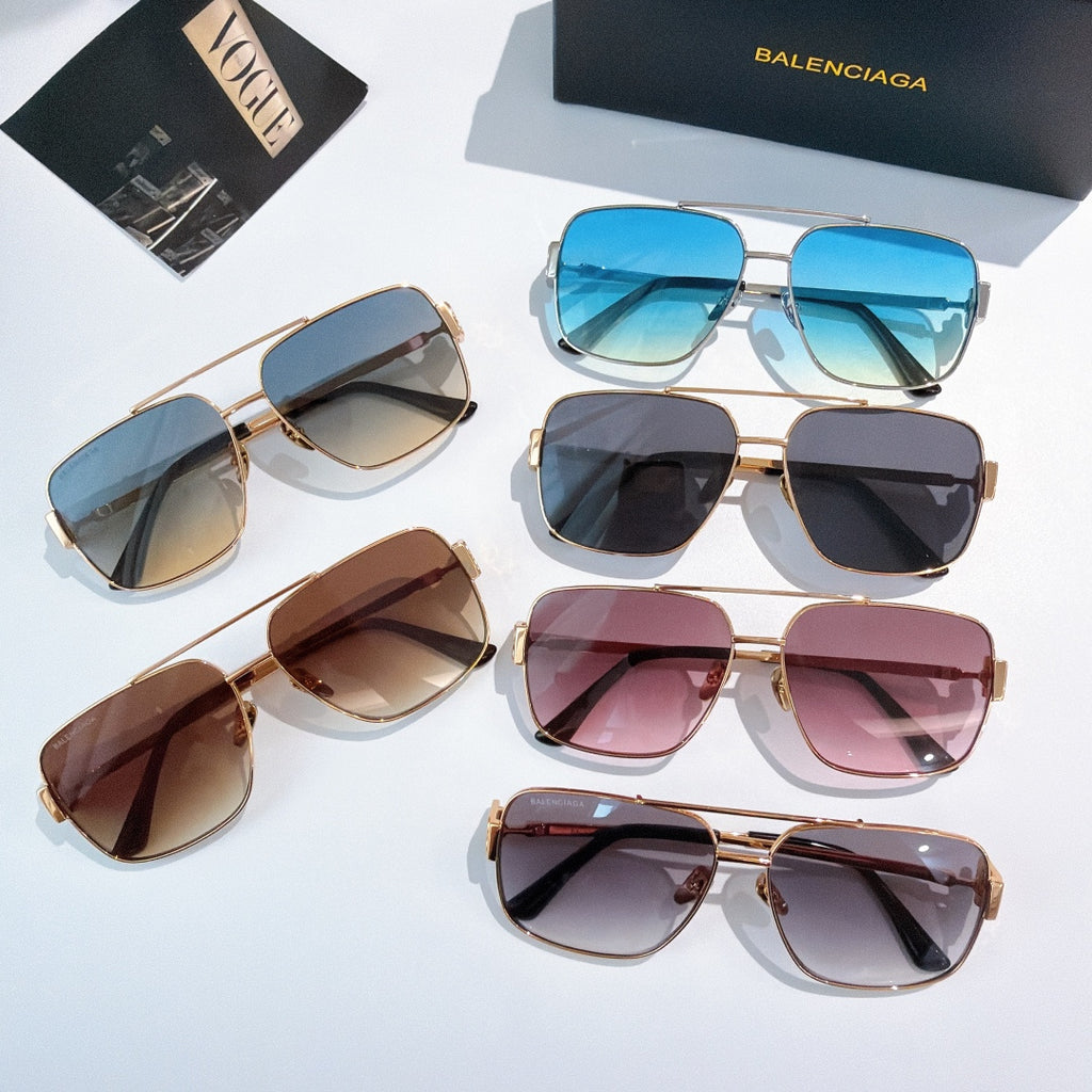 Assorted gold-framed sunglasses with tinted lenses in blue, black, brown, and pink
