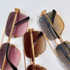 Set of gold-framed sunglasses with mixed tinted lenses in purple, brown, and blue